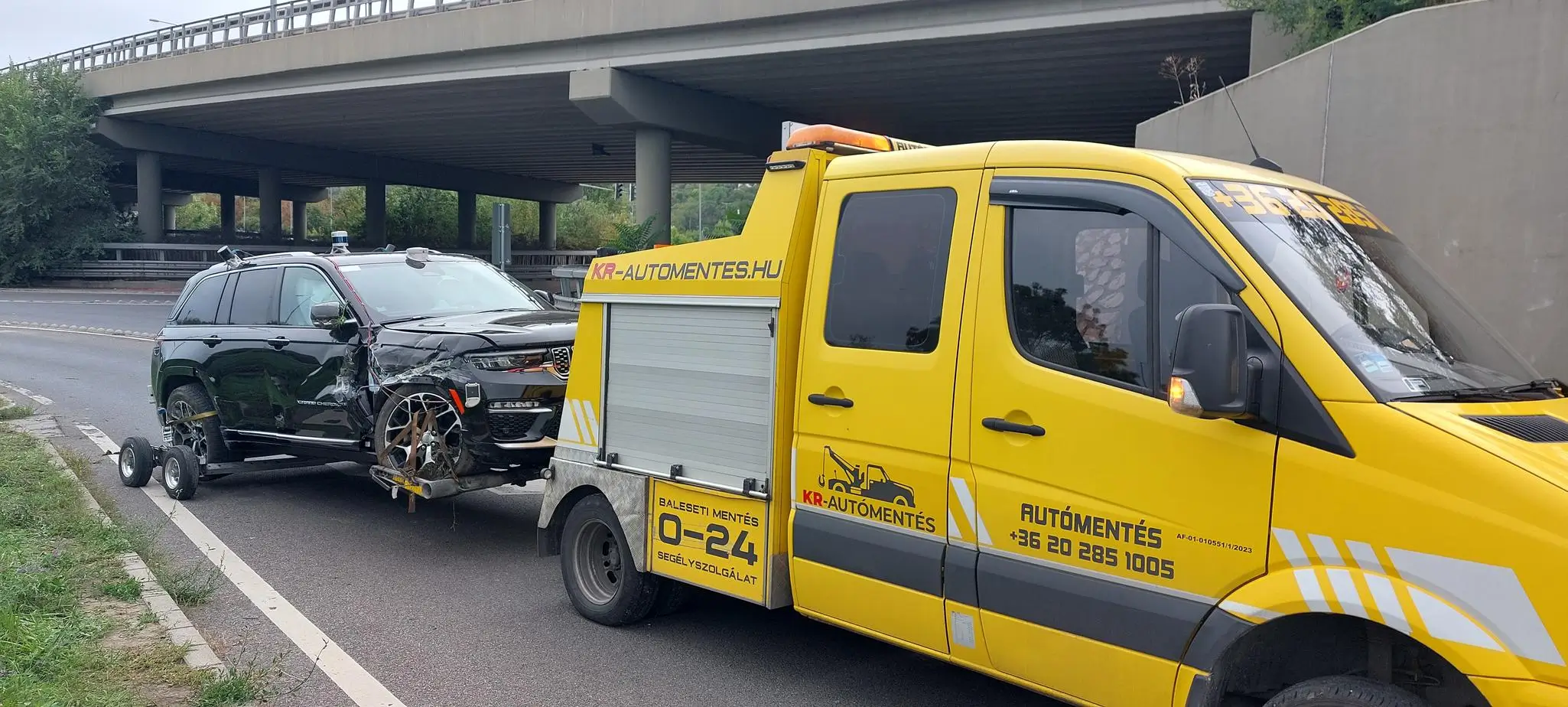 Autómentő szolgálat Solymár mellett egy szervíz előtt parkoló járművel