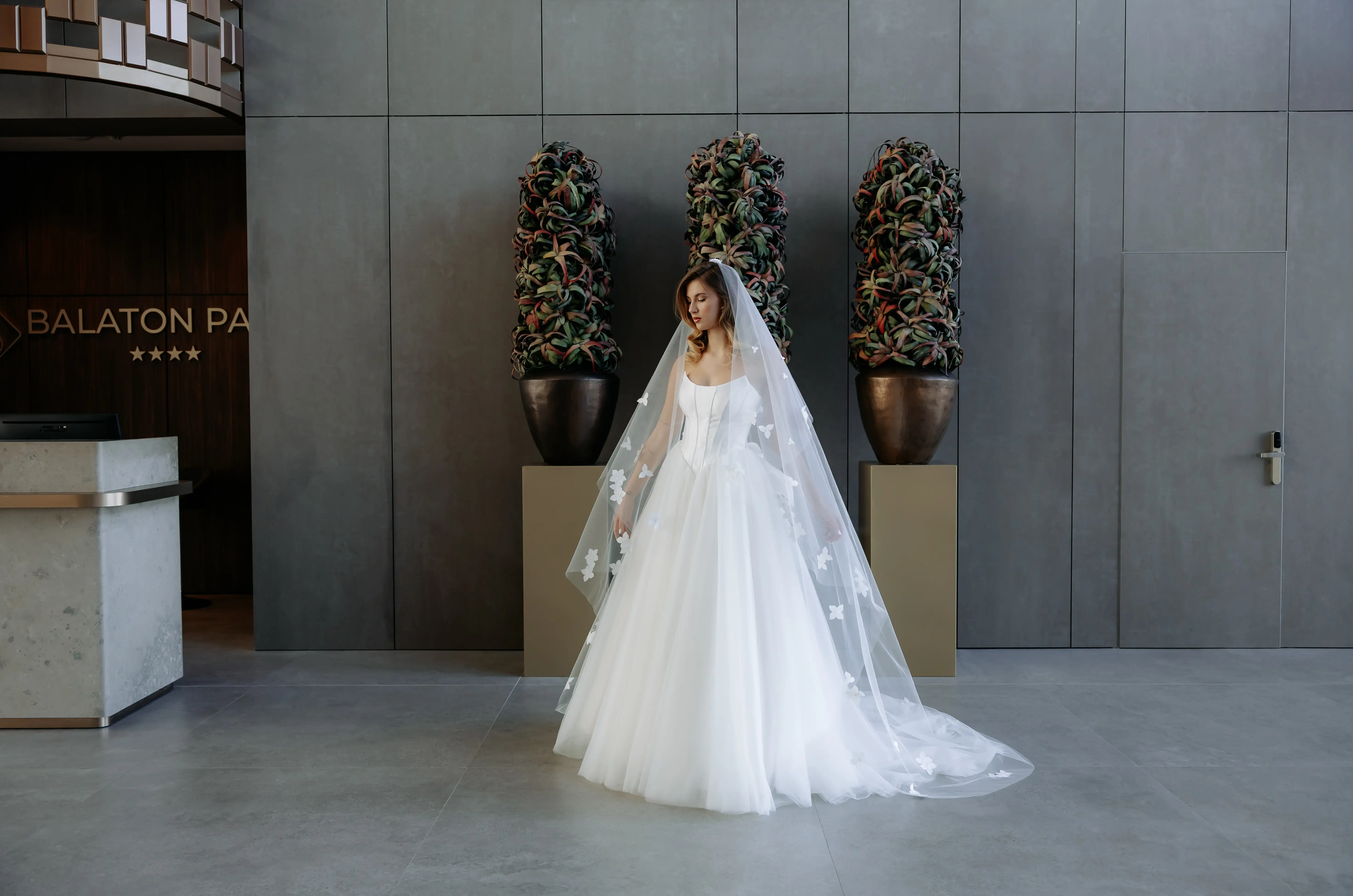 Női menyasszonyi ruha próbája próbababán, elegáns esküvői ruhák között.