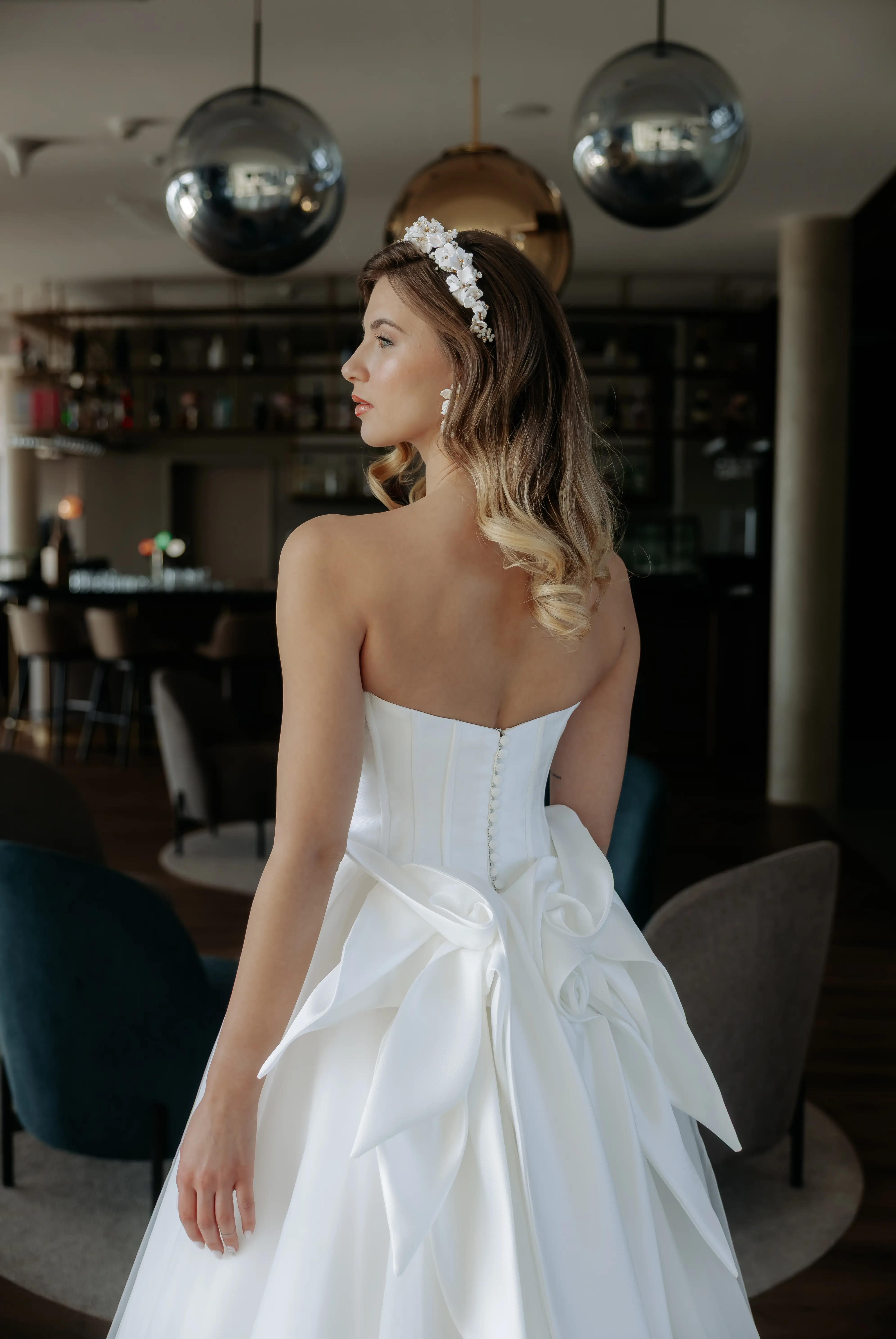 Női menyasszonyi ruha próbáján, a tükör előtt, örömteli arckifejezéssel próbálja ki esküvői ruháját