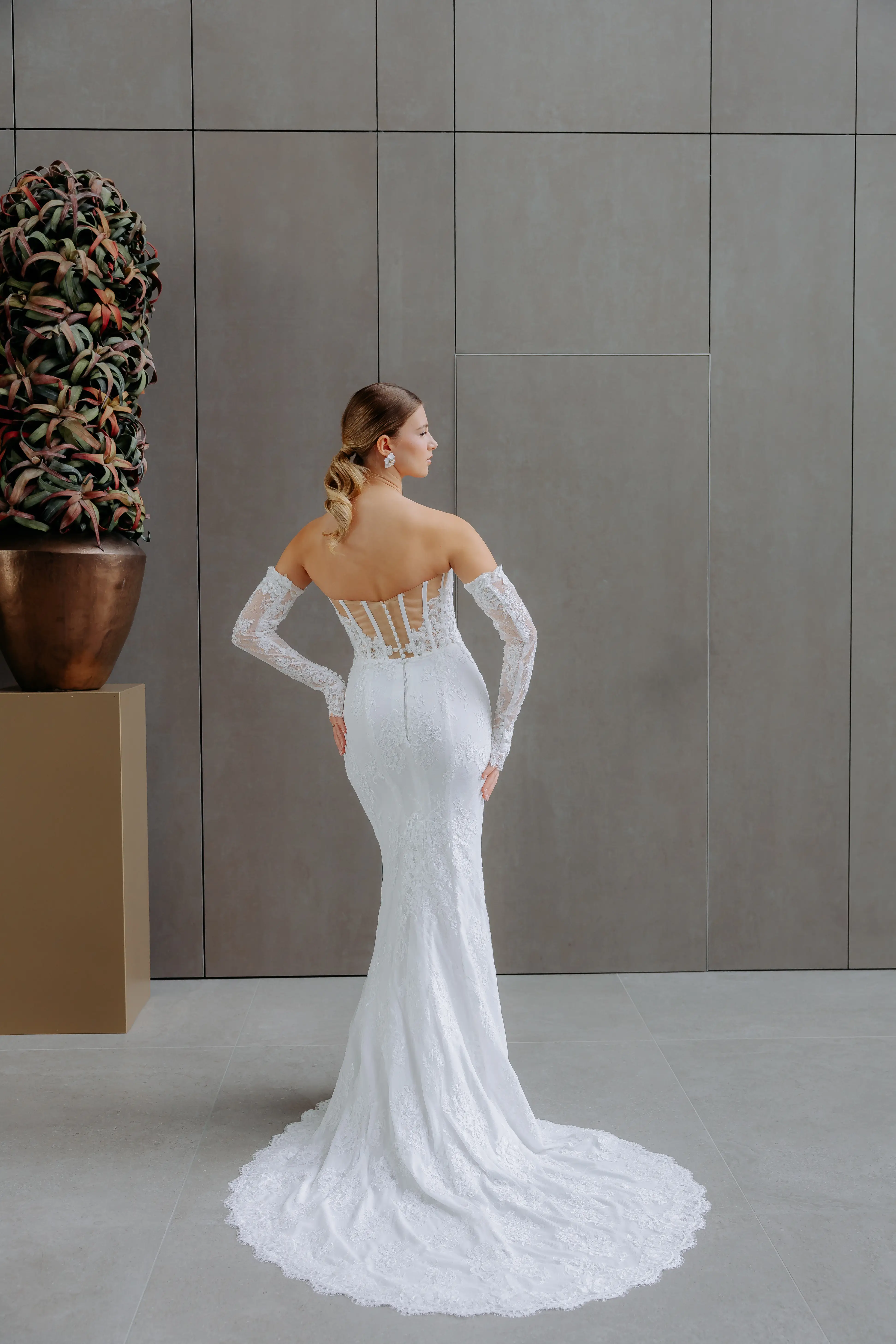 Egy elegáns menyasszony egy fehér esküvői ruhában, virágcsokorral a kezében egy szép kertben.