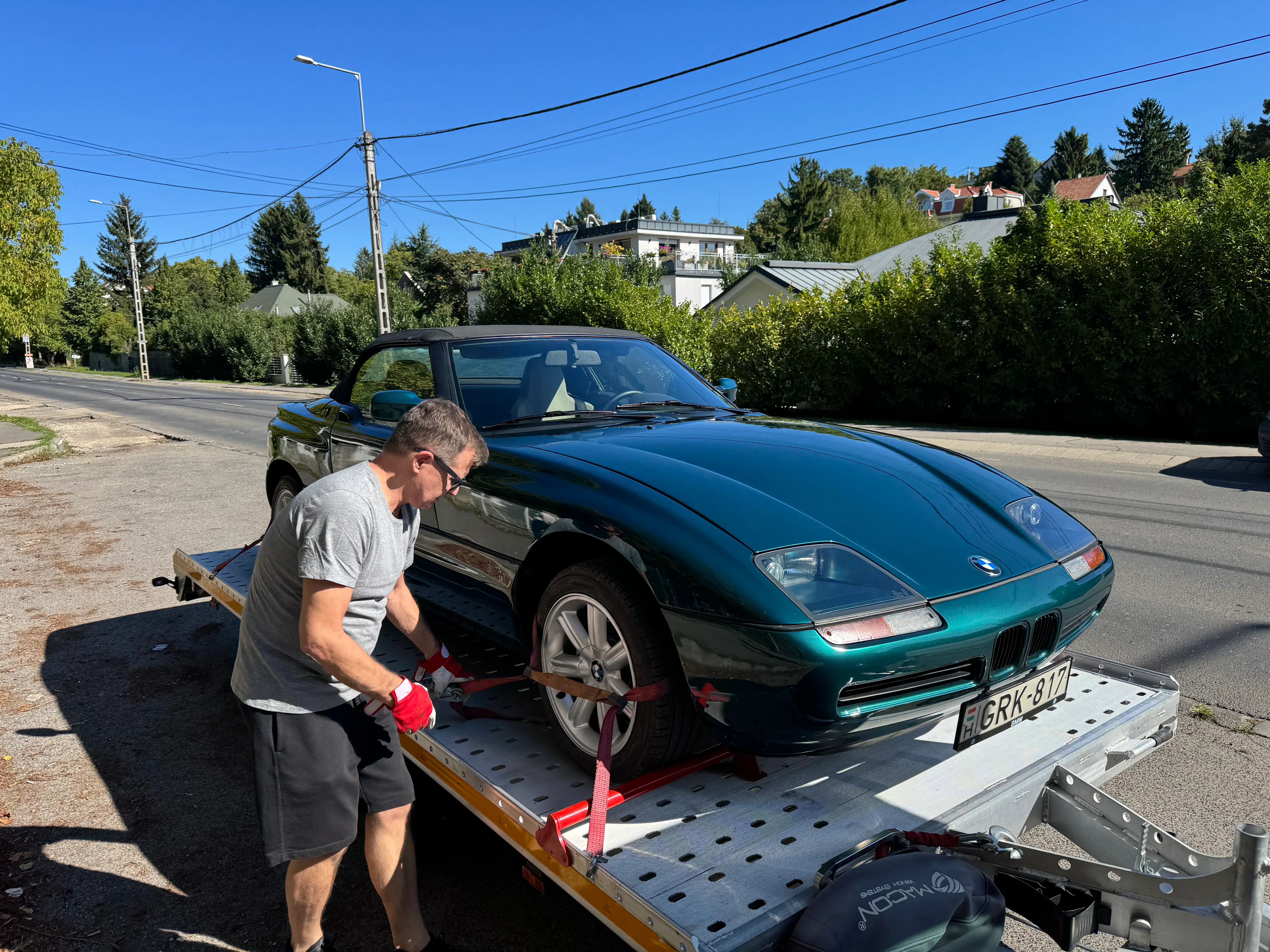 Autószállító jármű parkol Solymár utcáján, készen áll a biztonságos autó szállítására.